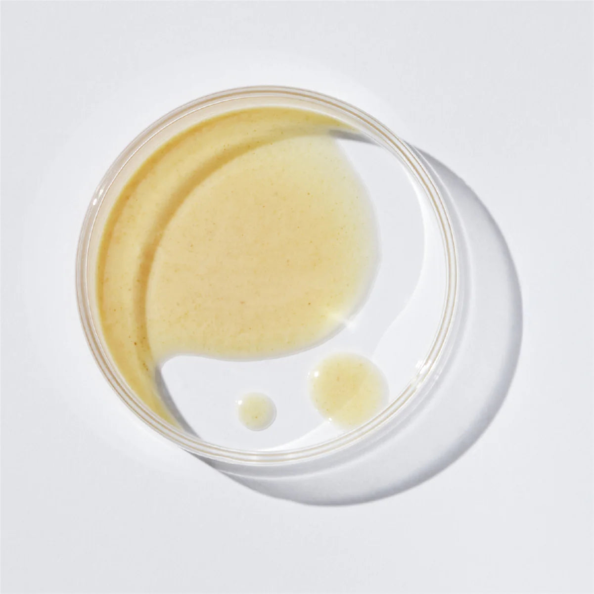 Jar of yellow cream on a white background